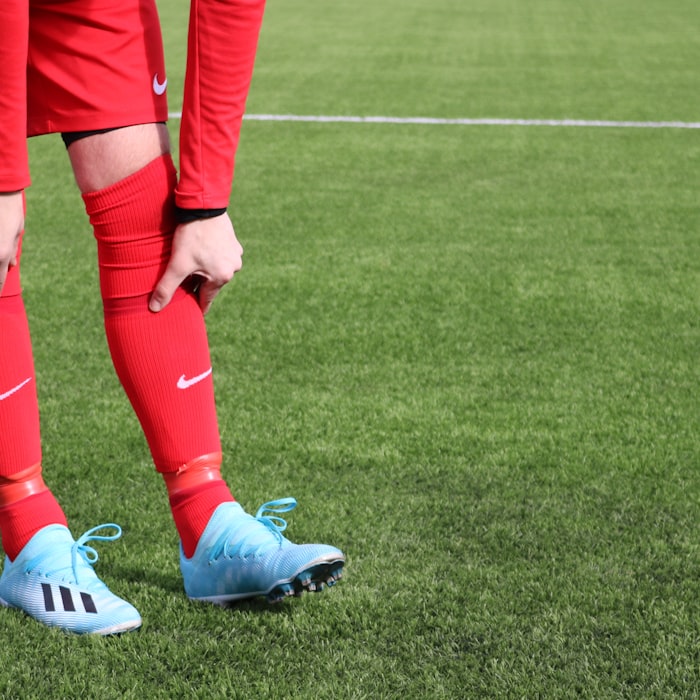 Fußballspieler in rot-blauer Spielkleidung auf dem Fußballplatz